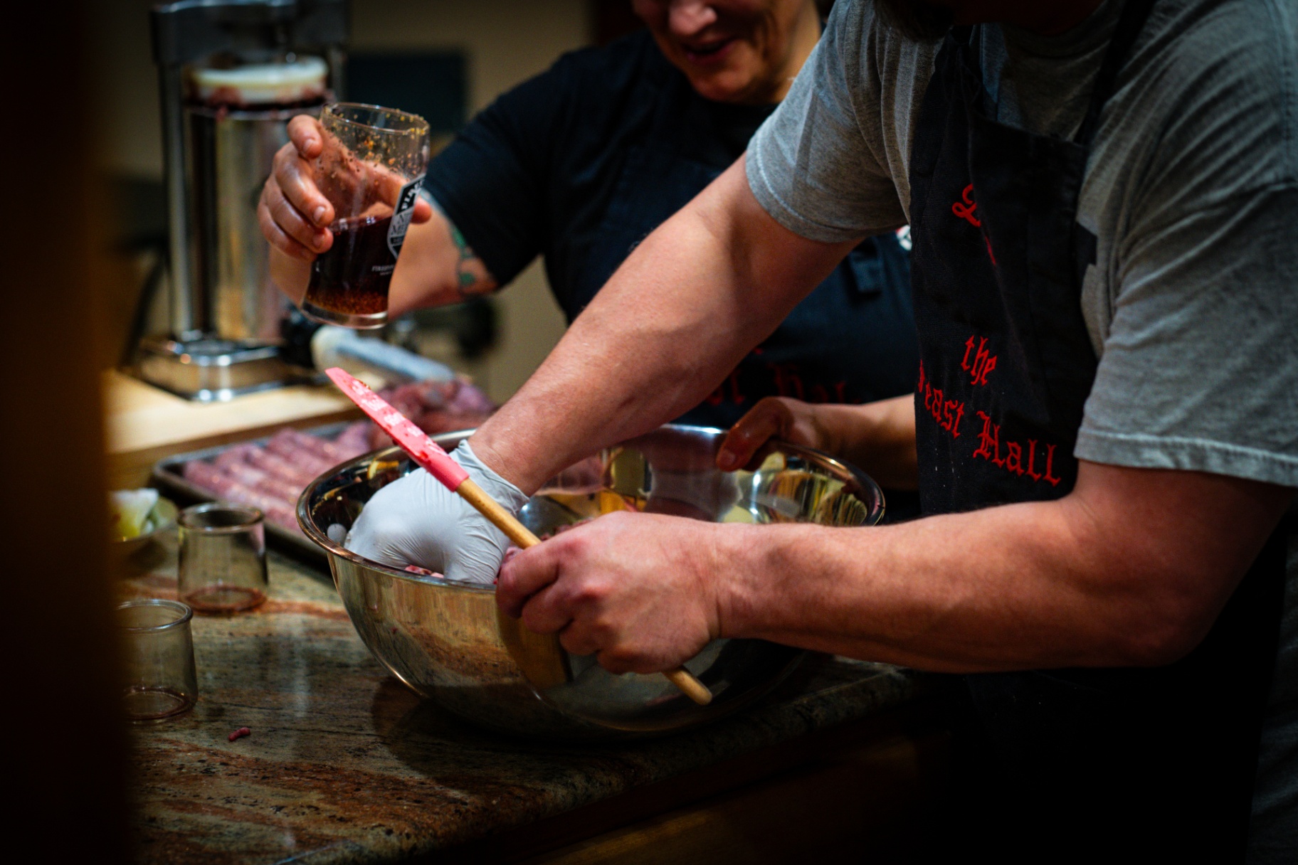 Feast Hall crew hand-mixing sausage with spices